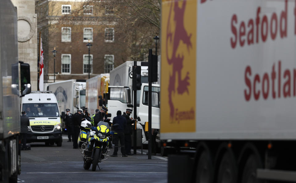 Police speak to shellfish export truck drivers as they are stopped for an unnecessary journey in London, Monday, Jan. 18, 2021, during a demonstration by British Shellfish exporters to protest Brexit-related red tape they claim is suffocating their business. The drivers were later stopped by police and issued with fines for an 'unnecessary journey' due to the national lockdown to curb the spread of the coronavirus. (AP Photo/Alastair Grant)