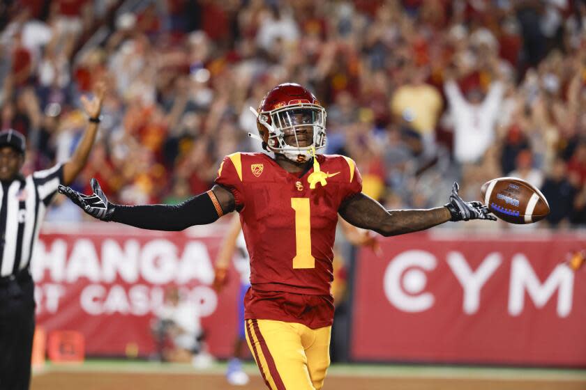 USC receiver Zachariah Branch extends his arms and celebrates after he returns a kickoff for a touchdown
