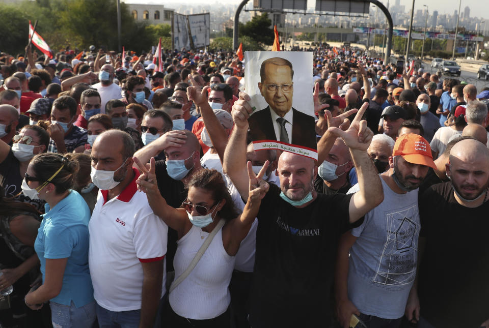 Supporters of Lebanese President Michel Aoun gather near the Presidential palace to support him against the anti-government protesters, in Baabda east of Beirut, Lebanon, Saturday, Sept. 12, 2020. Lebanese soldiers on Saturday fired rubber bullets and live rounds in the air to disperse hundreds of protesters trying to march to the presidential palace during an anti-government demonstration. (AP Photo/Bilal Hussein)