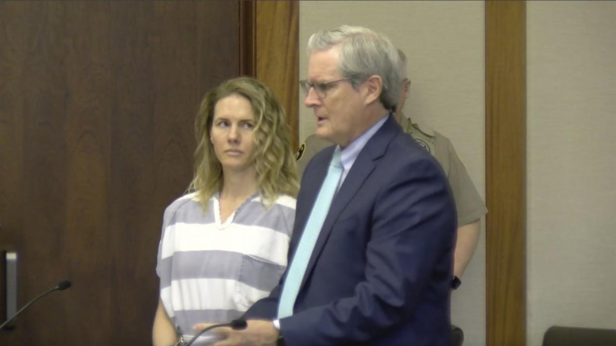 ruby franke wearing striped prison attire and looking over at an attorney during a court hearing