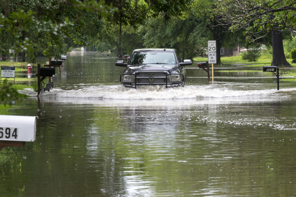 A pickup truck maneuvers a residential street filled with water in Woodloch, Texas, subdivision near The Woodlands as floodwaters rise Friday, May 3, 2024. Torrential rain is inundating southeastern Texas, forcing schools to cancel classes and closing numerous highways around Houston. (Kirk Sides/Houston Chronicle via AP)