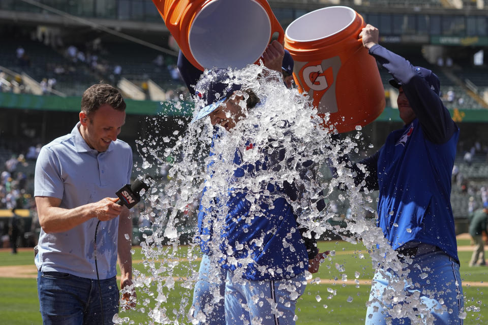 Toronto Blue Jays pitcher Kevin Gausman, center, is doused with water by teammates after the team's 7-0 victory over the Oakland Athletics in a baseball game Saturday, June 8, 2024, in Oakland, Calif. (AP Photo/Godofredo A. Vásquez)