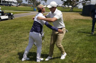 Rory McIlroy, of Northern Ireland, right, greets 2021 U.S. Women's Open golf champion Yuka Saso, of the Philippines, during a practice round of the U.S. Open Golf Championship, Tuesday, June 15, 2021, at Torrey Pines Golf Course in San Diego. (AP Photo/Gregory Bull)