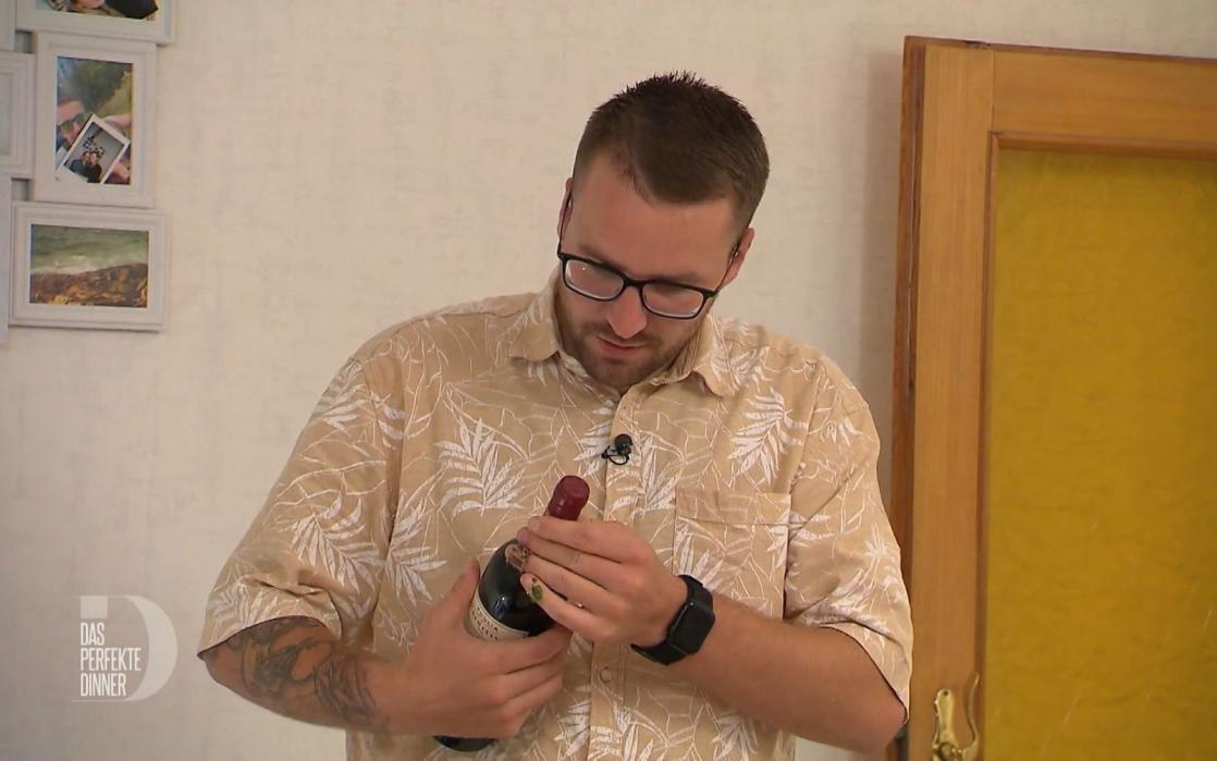 Das Öffnen des Rotweins zum Hauptgang stellt Tim heute vor die größte Herausforderung.
 (Bild: RTL)