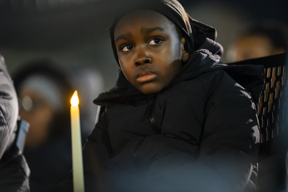 A young boy holds a candle as he listens to the names of homicide victims read aloud during a vigil for the homicide victims of 2023 on Wednesday, Jan. 3, 2023 in Baltimore. Mayor Brandon Scott hosted the vigil. (Kaitlin Newman /The Baltimore Banner via AP)