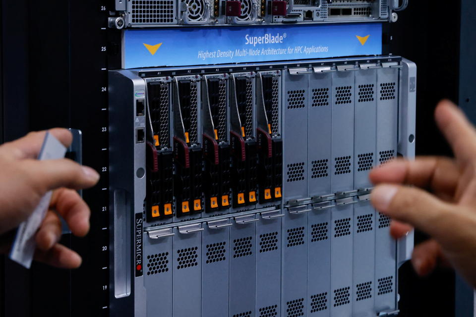 People point at a server on display at Super Micro Computer booth at COMPUTEX Taipei, one of the world's largest computer and technology trade shows, in Taipei, Taiwan May 30, 2023. REUTERS/Ann Wang