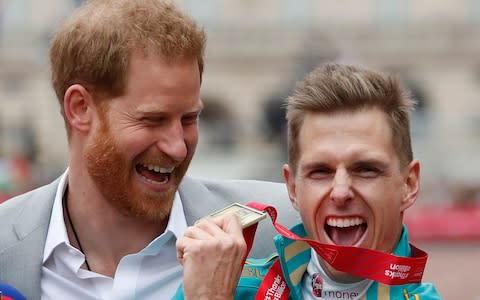 Prince Harry with the winner of the World Para marathon T 45/46 category Michael Roger - Credit: AP Photo/Alastair Grant
