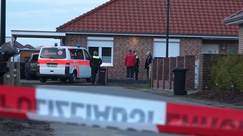 Emergency services stand behind a cordon. The police are investigating after shots were fired in the district of Rotenburg. There are two crime scenes - one in a detached house in Westervesede in the municipality of Scheessel and another in Bothel in the district of Rotenburg. Kai Moorschlatt/NordwestMedia TV/dpa