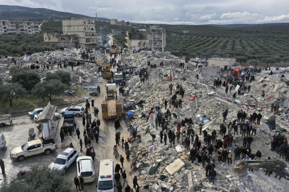 Trabajadores de defensa civil y residentes buscan entre los escombros de edificios derrumbados en el pueblo de Harem, provincia Idlib, Siria, el lunes 6 de febrero de 2023. Un poderoso sismo causó extenso daño en Turquía y Siria. (AP Foto/Ghaith Alsayed)