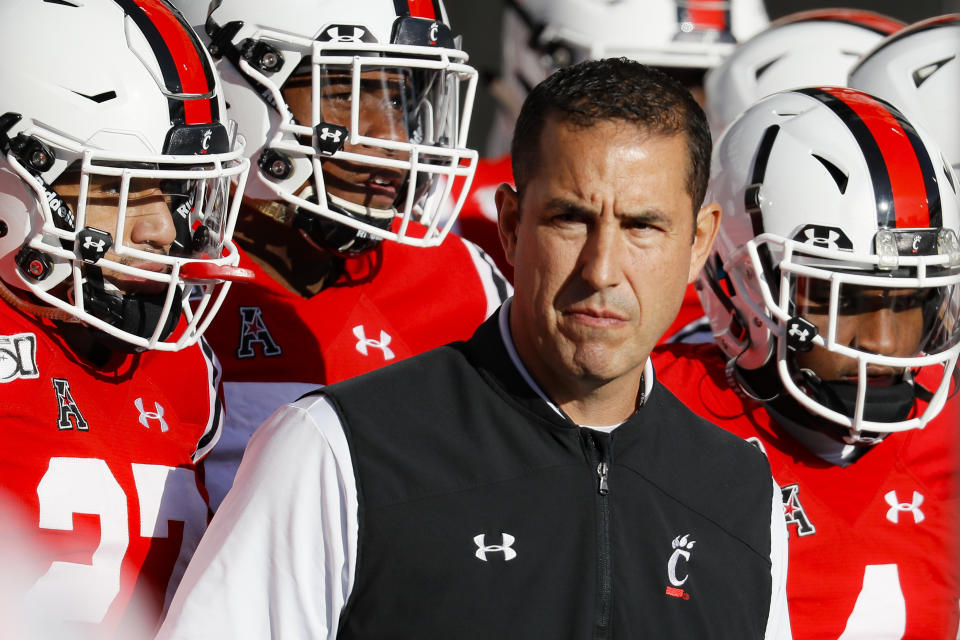 FILE - In this Saturday, Nov. 9, 2019, file photo, Cincinnati head coach Luke Fickell takes the field with his players before the first half of an NCAA college football game against Connecticut, in Cincinnati. Normally, in March, college football teams would be preparing for the upcoming season. Because of the new coronavirus pandemic, coaches are trying to figure out how to recreate some of what has been lost. Fickell said his goal is to try give his players a routine, including workout regimens they can do on their own without access to local gyms. They will also have online meetings with position groups and assistant coaches. (AP Photo/John Minchillo, File)