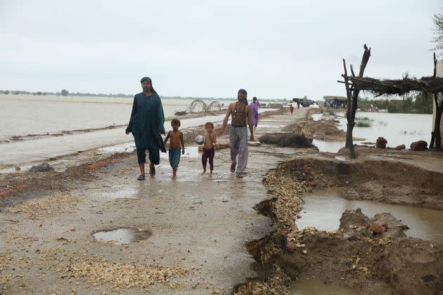 Displaced people are seen at a flooded area following the deadly climate catastrophe in Dadu, Pakistan on Aug. 29. (Photo: Anadolu Agency via Getty Images)