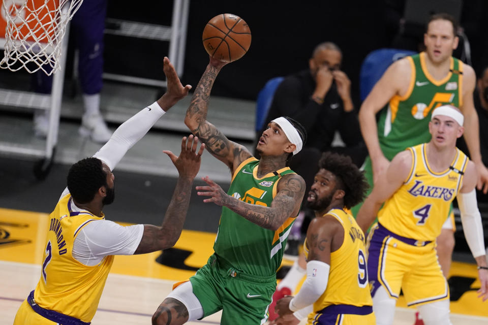 Utah Jazz guard Jordan Clarkson, center, shoots over Los Angeles Lakers center Andre Drummond, left, during the first half of an NBA basketball game Monday, April 19, 2021, in Los Angeles. (AP Photo/Marcio Jose Sanchez)