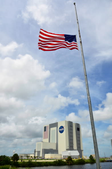 The U.S. flag flies at half mast outside the Vehicle Assembly Building in honor of Neil Armstrong at the Kennedy Space Center, August 31, 2012 in Cape Canaveral, Florida. Armstrong, the first man to walk on the moon, died from complications from heart surgery at the age of 82. (Photo by Roberto Gonzalez/Getty Images)