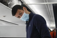 Novak Djokovic prepares to take his seat on a plane to Belgrade, in Dubai, United Arab Emirates, Monday, Jan. 17, 2022. Djokovic was deported from Australia on Sunday after losing a bid to stay in the country to defend his Australian Open title despite not being vaccinated against COVID-19.(AP Photo/Darko Bandic)