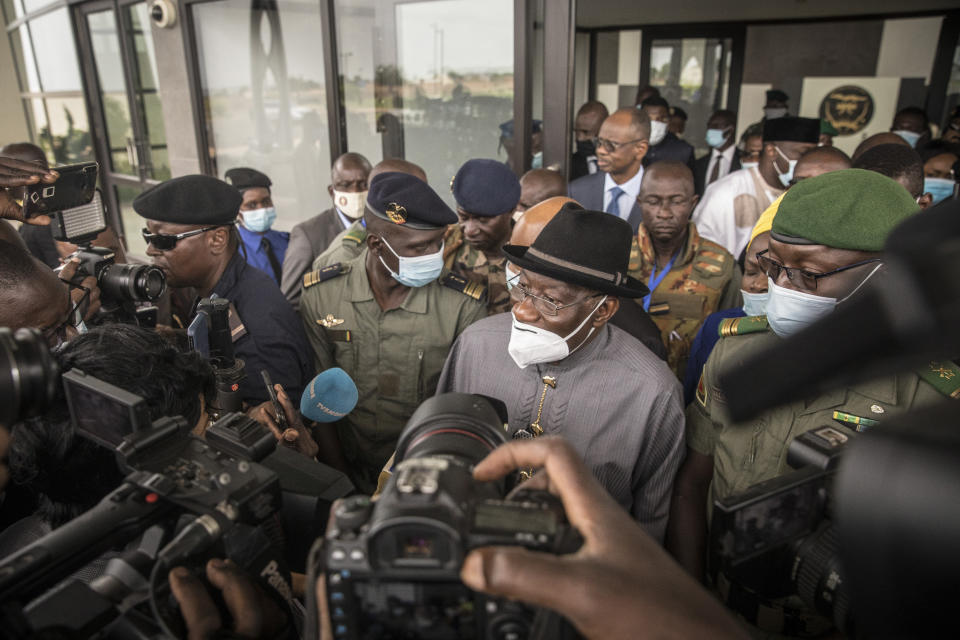 Former Nigerian president Goodluck Jonathan, center, speaks to the media after being welcomed by spokesman for the National Committee for the Salvation of the People (CNSP) Ismael Wague, center-left, and CNSP official Malick Diaw, right, upon his arrival at the airport in Bamako, Mali Saturday, Aug. 22, 2020. Top West African officials are arriving in Mali's capital following a coup in the nation this week to meet with the junta leaders and the deposed president in efforts to negotiate a return to civilian rule. (AP Photo)