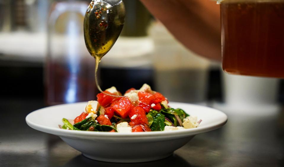 Sarah Kurz drizzles Carolina reaper honey on watermelon salad at The Local in Naples on April 11, 2023.