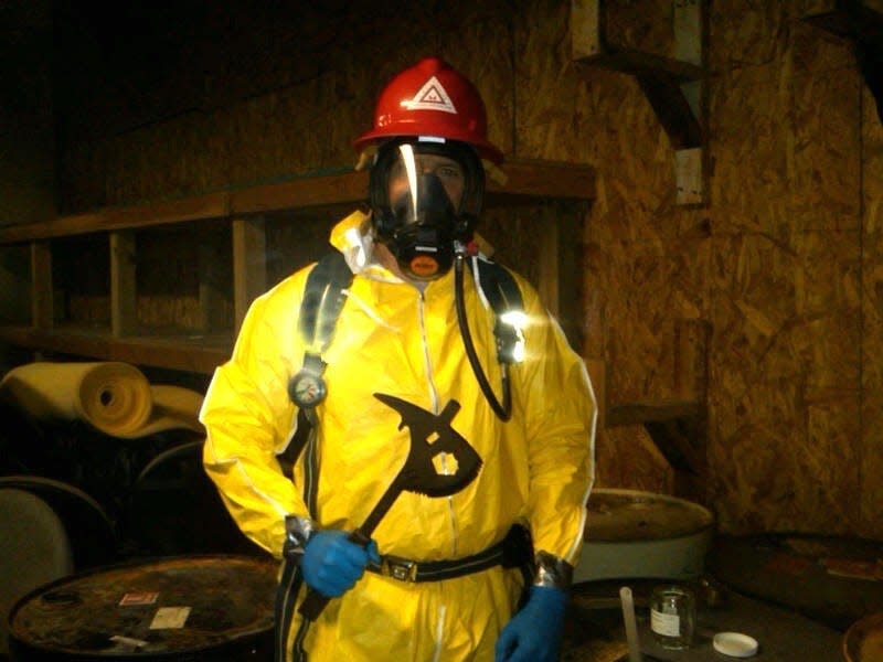 EPA on-scene coordinator Brian Kelly wears a yellow protective suit.