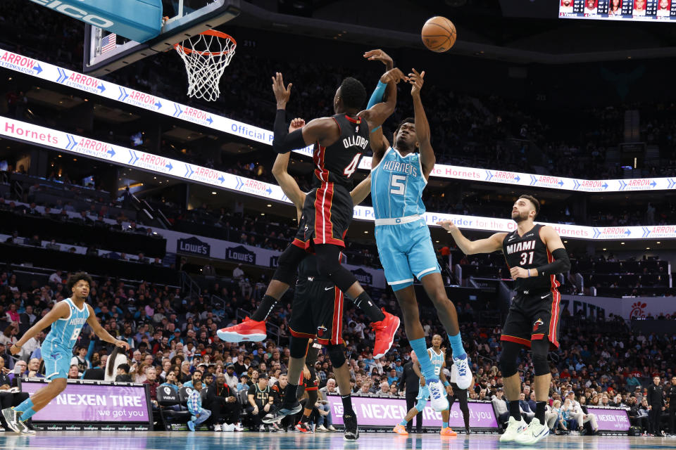 Charlotte Hornets center Mark Williams (5) and Miami Heat guard Victor Oladipo (4) battle for a rebound during the first half of an NBA basketball game in Charlotte, N.C., Sunday, Jan. 29, 2023. (AP Photo/Nell Redmond)