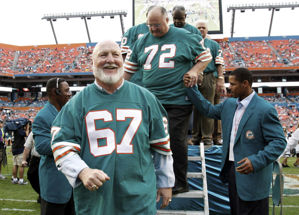 FILE - In this Dec. 16, 2007, file photo, players from the 1972 Miami Dolphins team, including guard Bob Kuechenberg (67) and defensive tackle Bob Heinz (72), walk off the stage following a ceremony honoring the team at a football game against the Baltimore Ravens at Dolphin Stadium in Miami. Former Dolphins guard Kuechenberg, a six-time Pro Bowl selection and member of the only NFL team to achieve a perfect season, died at age 71. His death Saturday, Jan. 12, 2019, was confirmed by the Dolphins, who had no further details. (AP Photo/Lynne Sladky, File)