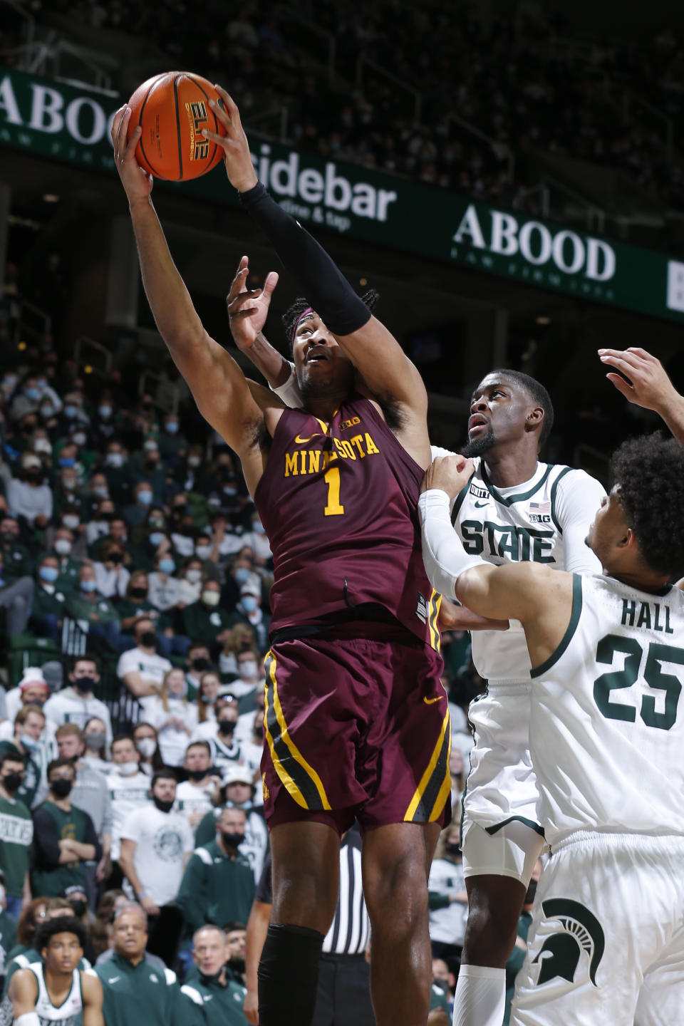 Minnesota's Eric Curry, left, and Michigan State's Gabe Brown reach for a rebound during the first half of an NCAA college basketball game, Wednesday, Jan. 12, 2022, in East Lansing, Mich. (AP Photo/Al Goldis)