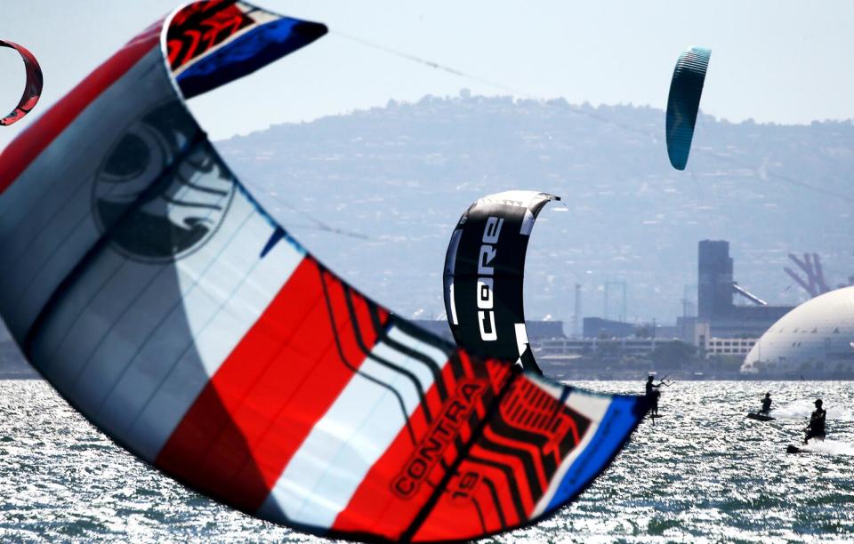 An archival photo of kitesurfers navigating calm summer seas at Belmont Shore.