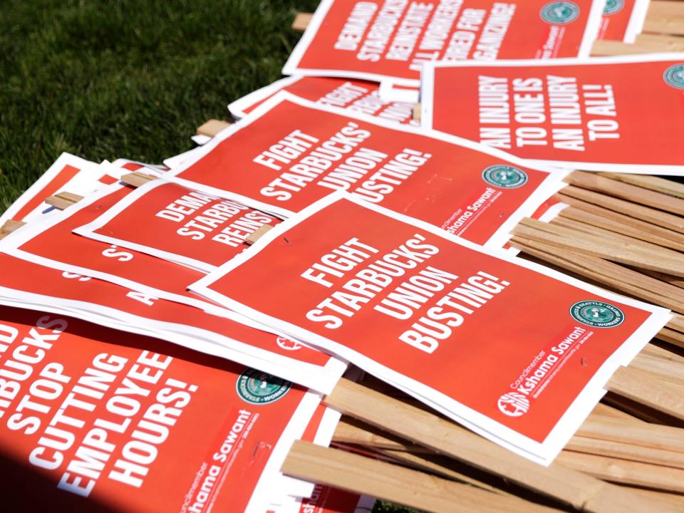 Picket signs are left for people to grab during the "Fight Starbucks' Union Busting" rally and march in Seattle, Washington on April 23, 2022