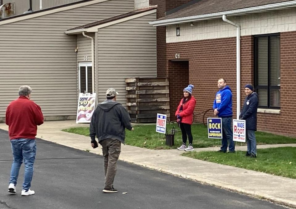 Voters arrive Tuesday morning at First Alliance Church, 2939 Zimmerly Road, as representatives of various political candidates stand outside the polling place for Millcreek Township's 22nd and 23rd districts.
