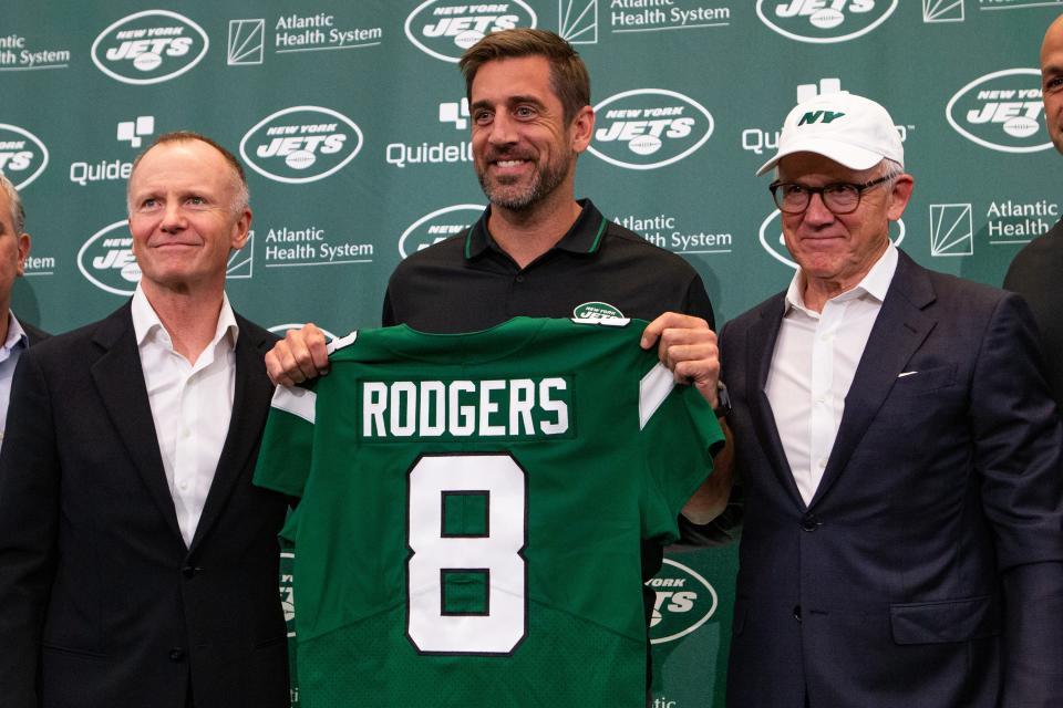 New York Jets quarterback Aaron Rodgers (8) poses for a photo with New York Jets owners Christopher Johnson (left) and Woody Johnson (right) during an introductory press conference at Atlantic Health Jets Training Center on April 26.