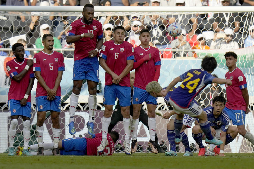 Los jugadores costarricenses defienden un tiro libre del japonés Yuki Soma durante el juego del Grupo E del Mundial entre ambos equipos, en el estadio Ahmad Bin Ali en Rayán, Qatar, el 27 de noviembre de 2022. (AP Foto/Francisco Seco)