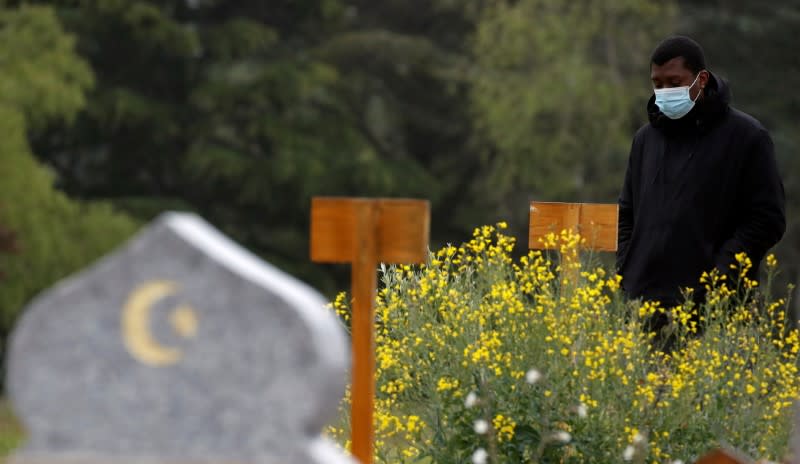 Mamadou Diagouraga stands next to the grave of his father, who died after being infected by the coronavirus disease (COVID-19)