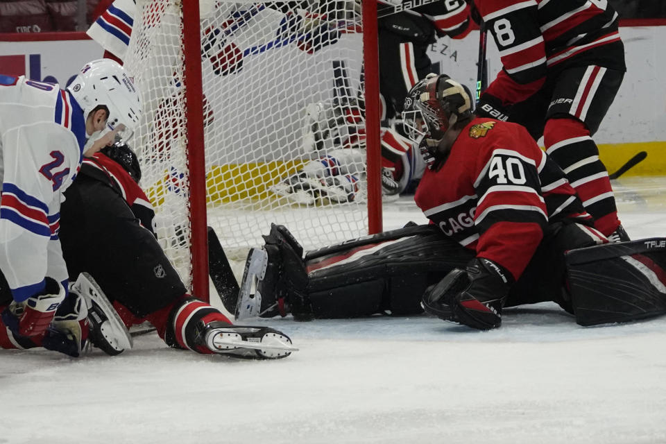 Chicago Blackhawks goaltender Arvid Soderblom (40) makes a save on New York Rangers right wing Kaapo Kakko (24) during the second period of an NHL hockey game, Sunday, Dec. 18, 2022, in Chicago. (AP Photo/David Banks)