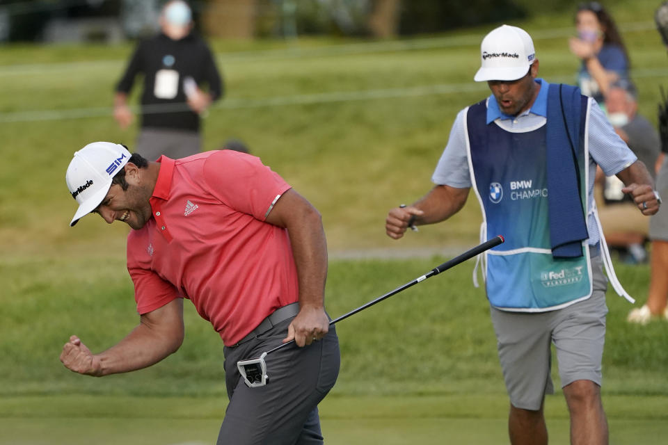 Jon Rahm, left, reacts after making his putt on the first playoff hole next to caddie Adam Hayes during the final round of the BMW Championship golf tournament at the Olympia Fields Country Club in Olympia Fields, Ill., Sunday, Aug. 30, 2020. (AP Photo/Charles Rex Arbogast)