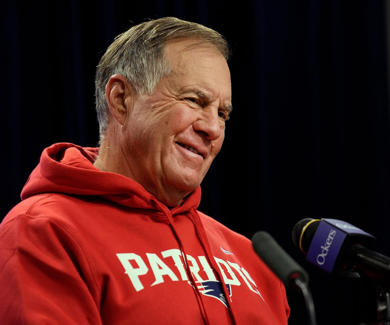 Bill Belichick smiles during questions at a press conference.