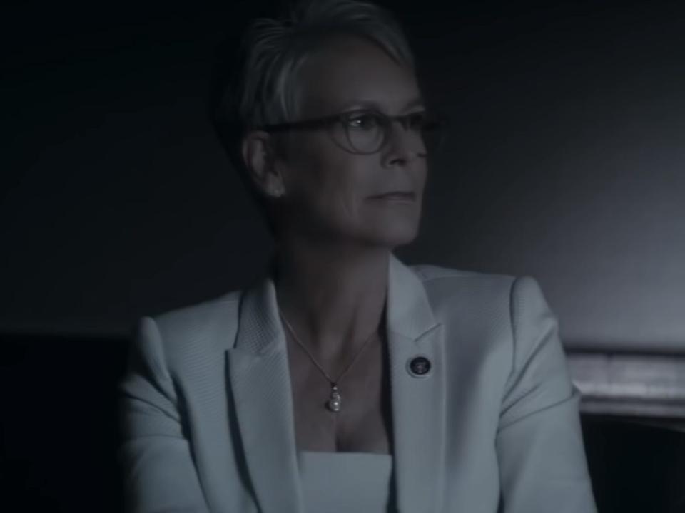 rachel wearing a white suit sitting in a dark room in an acceptable loss