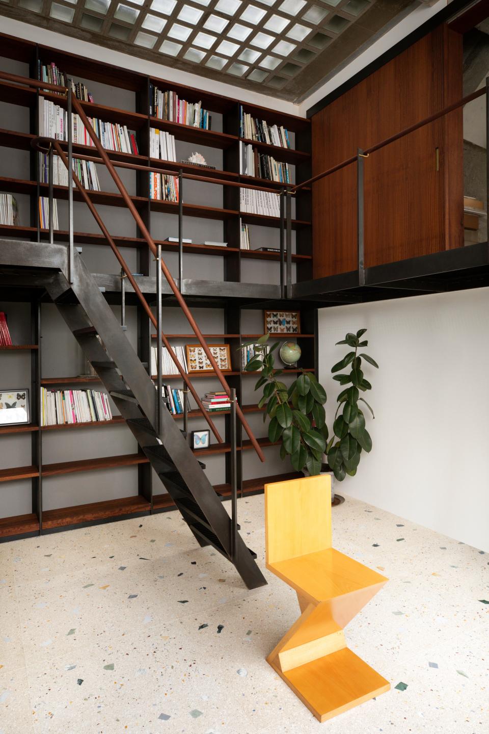 Chong transformed an extra bedroom into a library (he mostly reads art books) with a wraparound walkway and staircase. A yellow Gerrit Rietveld chair adds a pop of color against the custom terrazzo floor.