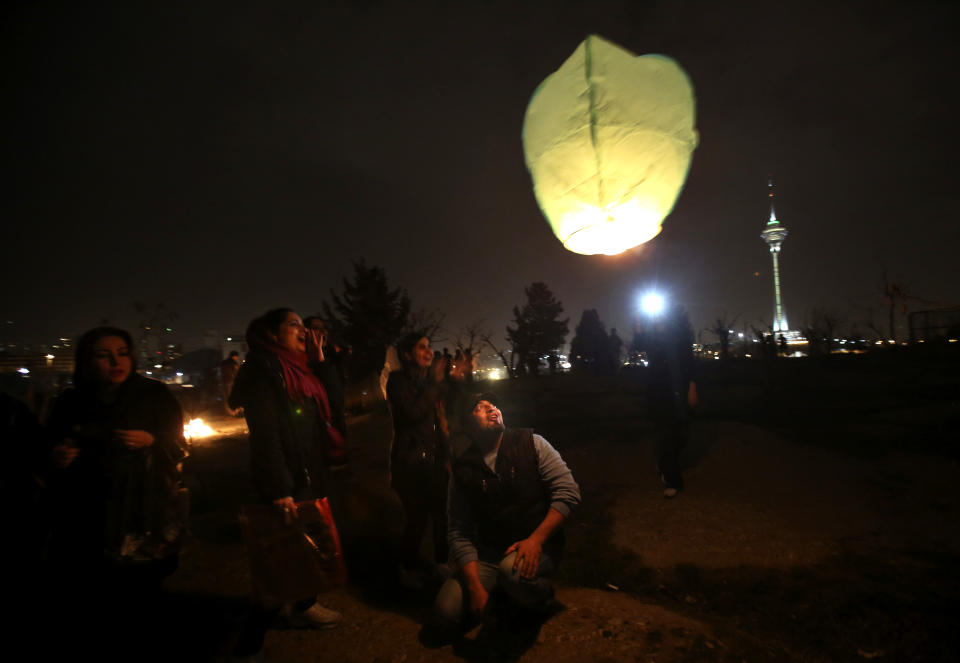 In this picture taken on Tuesday, March 18, 2014, Iranians release a lit lantern during a celebration, known as “Chaharshanbe Souri,” or Wednesday Feast, marking the eve of the last Wednesday of the solar Persian year, in Pardisan park, Tehran, Iran. March 21, the first day of spring, marks Nowruz, the beginning of the year 1393 on the Persian calendar. (AP Photo/Vahid Salemi)