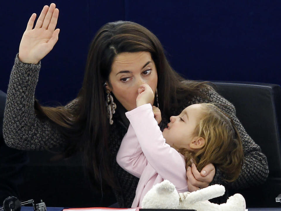 Conciliar la vida laboral y la familiar no siempre resulta fácil. Para demostrarlo, ahí estaba la parlamentaria italiana Licia Ronzulli, quien ni corta ni perezosa se llevó a su pequeña al Parlamento Europeo. La niña se lo tomó todo lo en serio que pudo, hasta levantó su manita para votar. (REUTERS/Vincent Kessler)