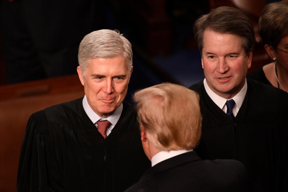 Supreme Court Associate Justices Neil Gorsuch, left, and Brett Kavanaugh greet President Donald Trump at a State of the Union address.