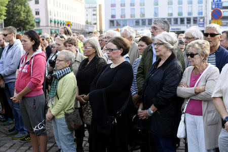 People attend a moment of silence to commemorate the victims of Friday's stabbings at the Turku Market Square in Turku, Finland August 20, 2017. Lehtikuva/Vesa Moilanen via REUTERS