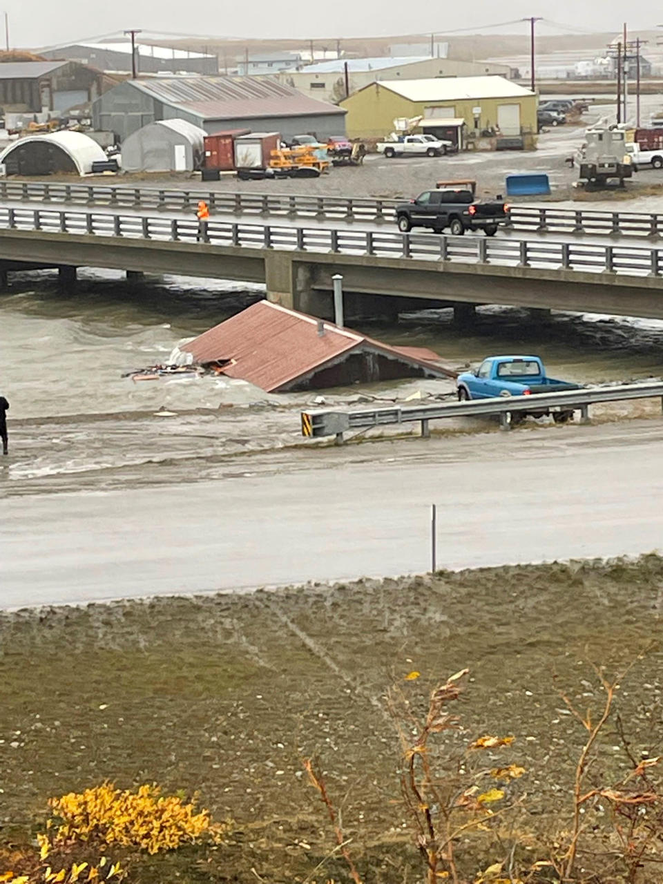 A home that was knocked off its foundation and floated down Snake River during a severe storm in Nome, Alaska, is caught under a bridge Saturday, Sept. 17, 2022. Much of Alaska's western coast was battered by the storm, which was the remnant of Typhoon Merbok, causing the most damage of any storm in the last half century. (AP Photo/Peggy Fagerstrom)