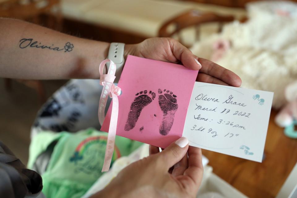Cassidy Crough, whose daughter Olivia was born still in March, 2022 holds her footprints, June 13, 2022 in New Milford, Conn. Crough is raising the alarm on New York's lack of paid leave for stillbirth moms. She gave birth to her deceased daughter Olivia in March, 2022 and under New York law, stillbirth moms don't qualify for the same paid family leave that new moms whose children live get.