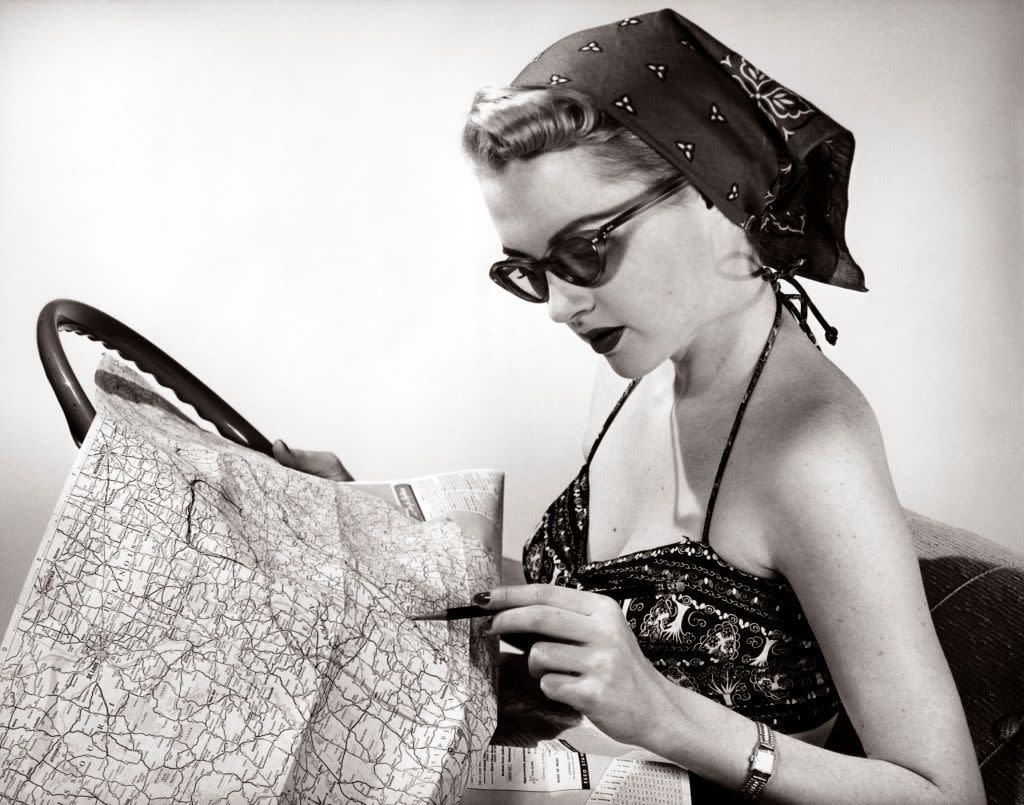 1950s WOMAN WEARING BANDANA SUNGLASSES & HALTER TOP MARKING ROAD MAP