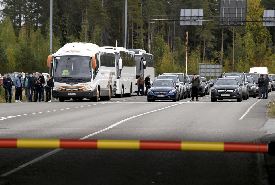 FILE - People traveling from Russia in cars and coaches queue to cross the border to Finland at the Vaalimaa border check point in Virolahti, Finland, Sunday, Sept. 25, 2022. MThe long border between Finland and Russia runs through thick forests and is marked only by wooden posts with low fences meant to stop stray cattle. Soon, a stronger, higher fence will be erected on parts of the frontier. (Jussi Nukari./Lehtikuva via AP, File)