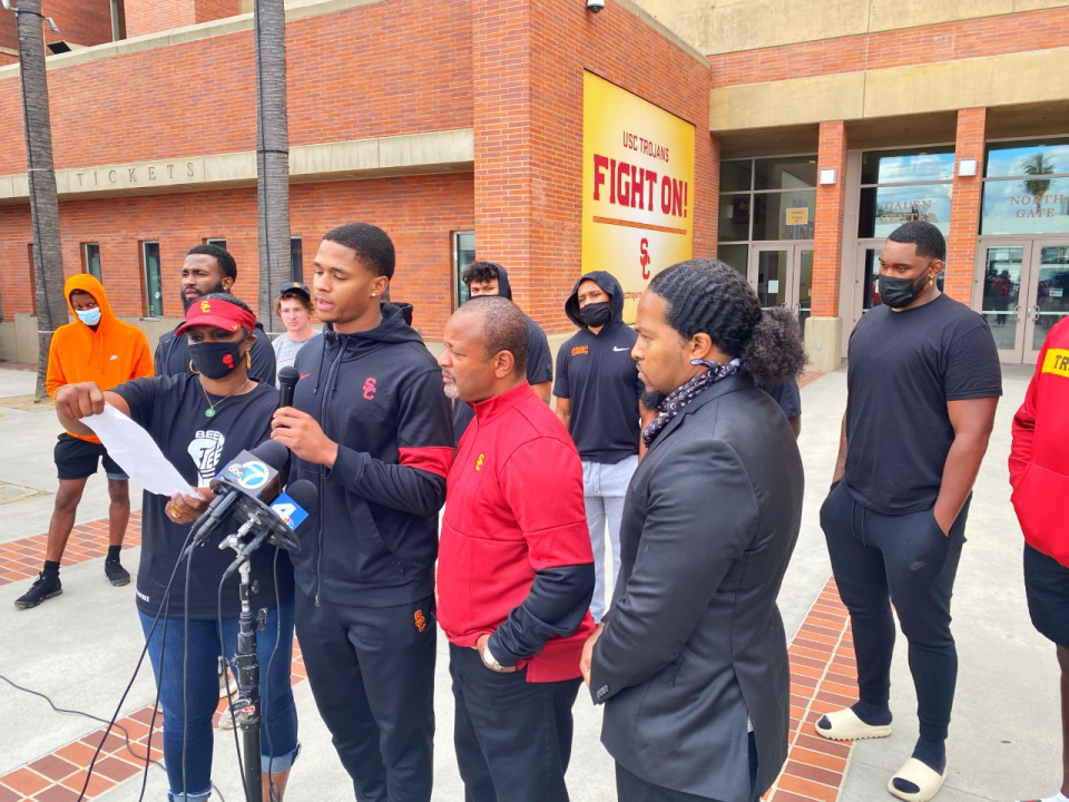 Munir McClain, center, speaks during a news conference outside the Galen Center on Oct. 25.