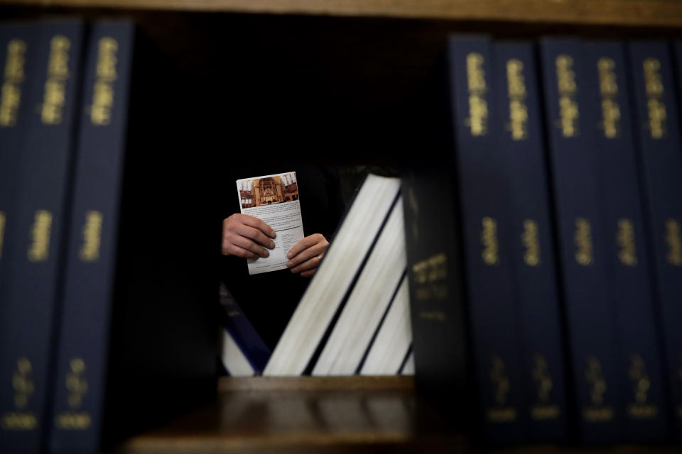 In this Jan. 17, 2020, photo Andy Kirschner holds a service program paper during the Friday Shabbat Service at KAM Isaiah Israel in Chicago. On the eve of the day set aside to honor an African American who strove against hate and preached racial and social justice, some worry the nation is becoming more divided. (AP Photo/Nam Y. Huh)