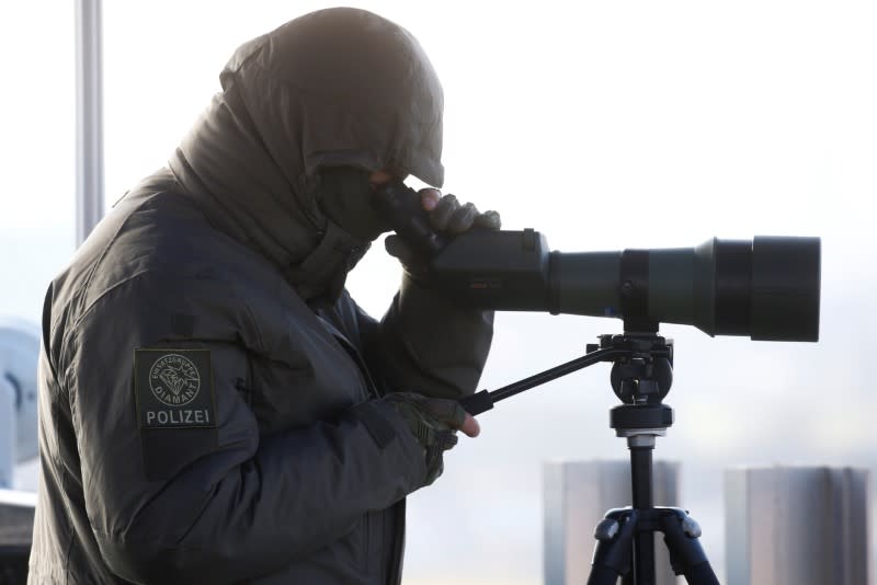 Police marksman looks through a spotting scope at the airport in Zurich