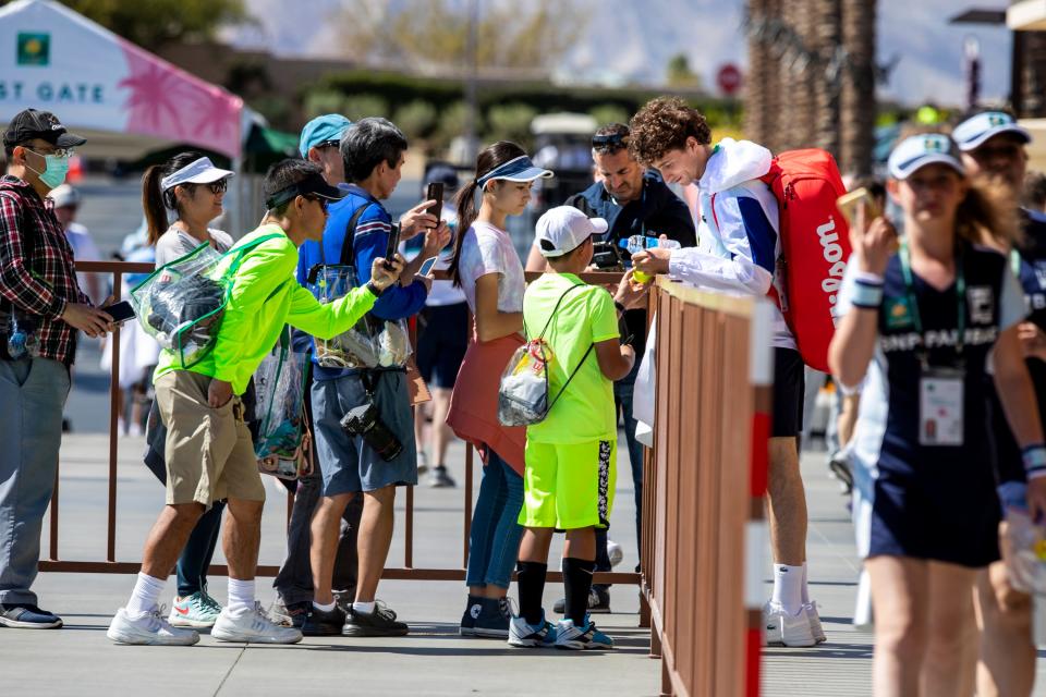 French player Ugo Humbert signs his autograph for fans during day one of the BNP Paribas Open in Indian Wells, Calif., on Monday, March 7, 2022.