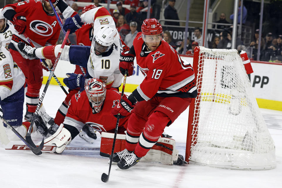 Carolina Hurricanes' Jack Drury (18) controls the puck as Florida Panthers' Anthony Duclair (10) collides with Hurricanes goaltender Frederik Andersen (31) during the first period of Game 1 of the NHL hockey Stanley Cup Eastern Conference finals in Raleigh, N.C., Thursday, May 18, 2023. (AP Photo/Karl B DeBlaker)