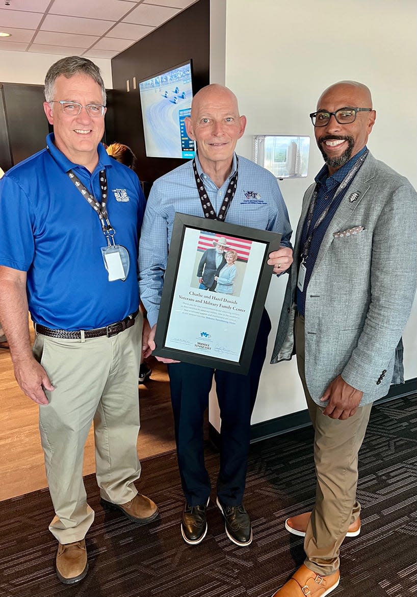 MTSU Provost Mark Byrnes, left, and retired U.S. Army Lt. Gen. Keith M. Huber, center, present Nashville Superspeedway President Erik Moses with a commemorative plaque of Hazel Daniels and her late husband, the legendary Charlie Daniels, Friday, June 24, at the Nashville Superspeedway in Gladeville, Tenn. The presentation occurred before the Rackley Roofing 200 NASCAR Camping World Truck Series event. Huber is senior advisor for veterans and leadership initiatives at MTSU.