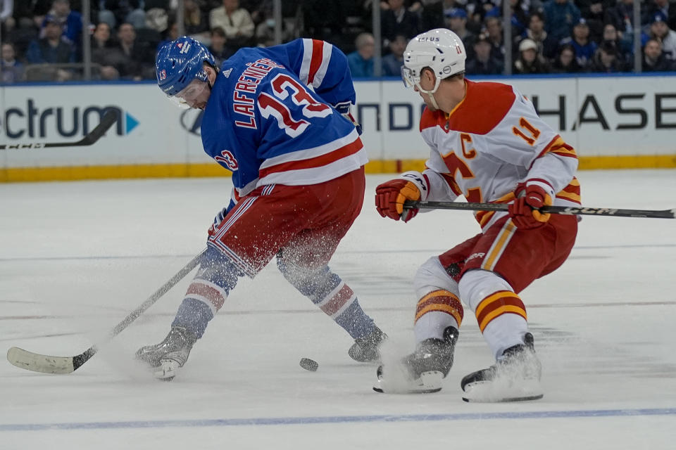 New York Rangers left wing Alexis Lafreniere (13) skates against Calgary Flames center Mikael Backlund (11) during the second period an NHL hockey game on Monday, Feb. 12, 2024, in New York. (AP Photo/Bryan Woolston)